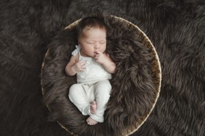Babyfotograf Hamburg - Baby liegt nuckelnd im
