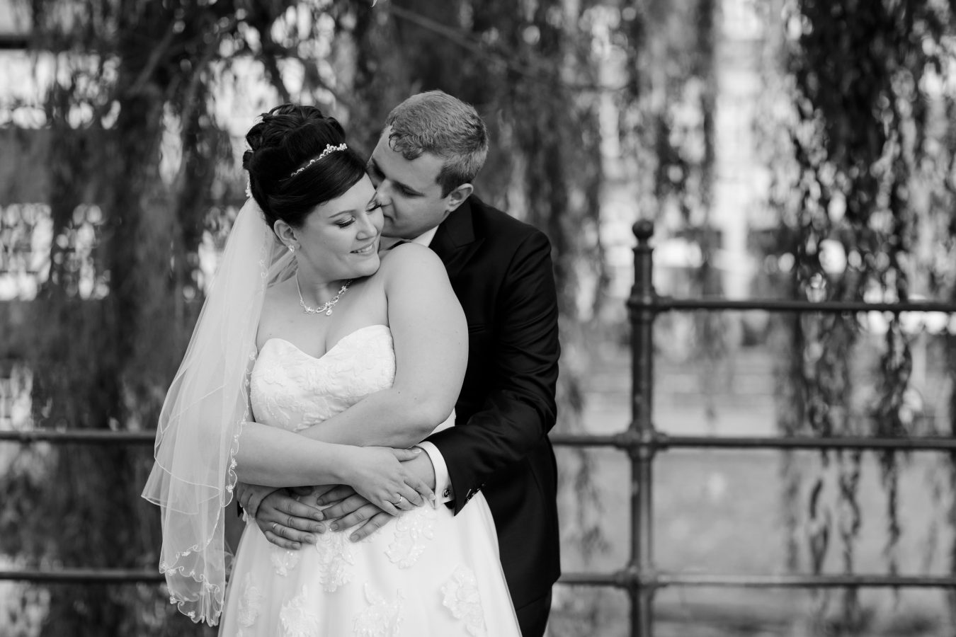 Hochzeitsfotograf Hamburg - Brautpaar steht innig unter Trauerweide