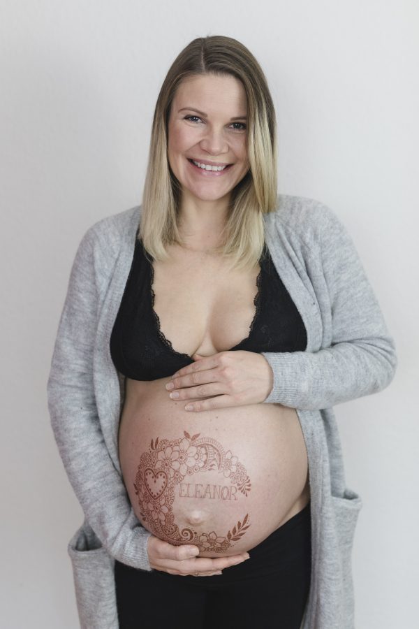 Babybauchfotograf Hamburg - Julia strahlt vor Glück mit ihrem fertigen Tattoo