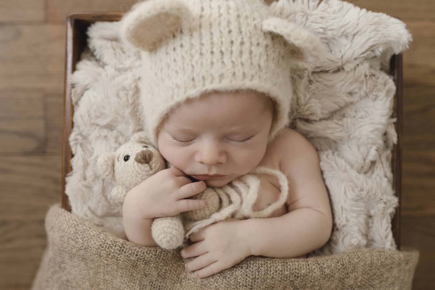 Newbornfotografie Hamburg - kleiner Junge kuschelt mit seinem Teddy