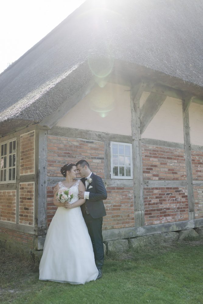 Hochzeitsfotos Buchholz - das Brautpaar steht hinter dem Sniers Hus und die Sonne scheint über das Dach