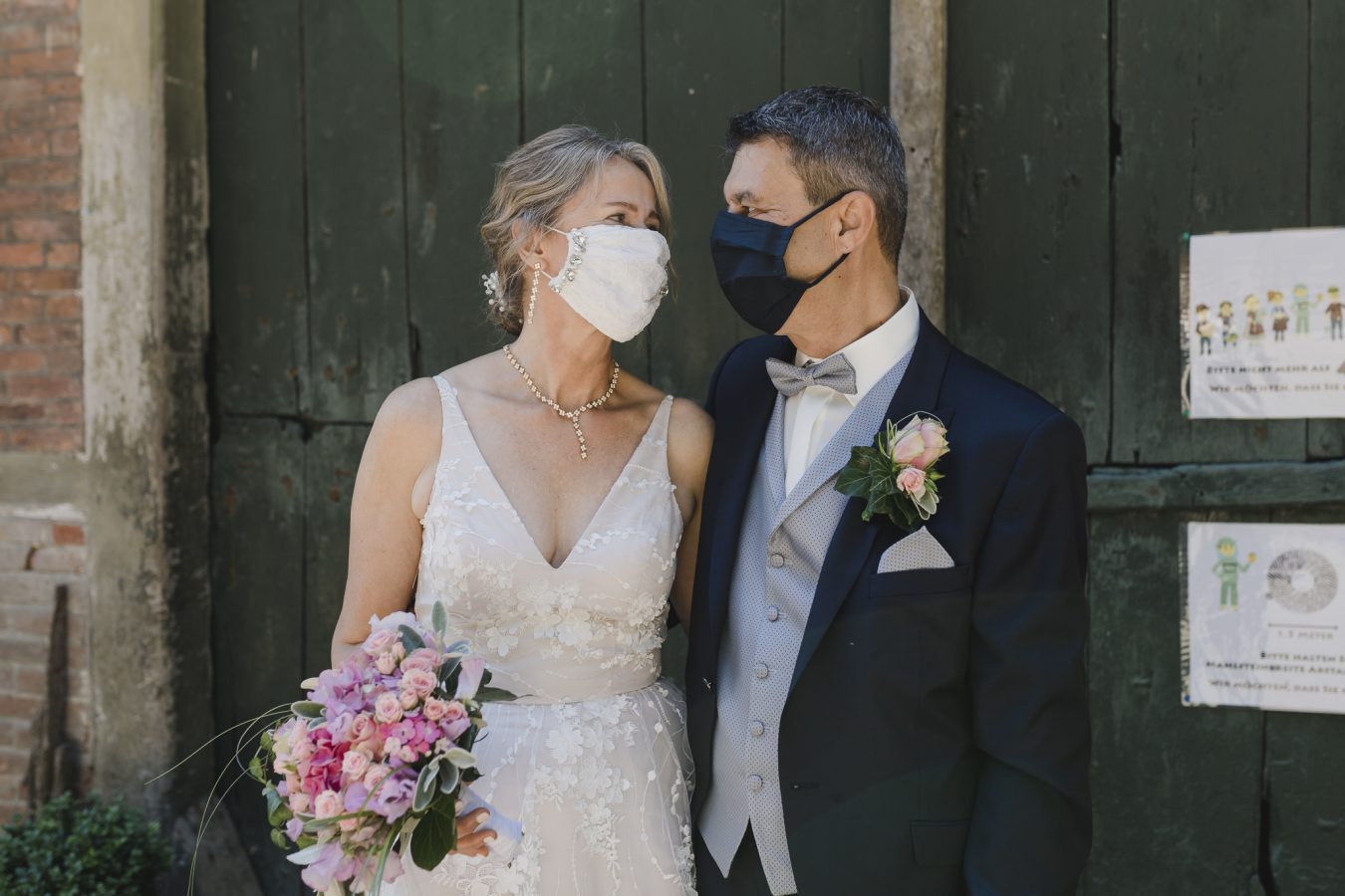Das Brautpaar trägt eine Maske bei ihrer Corona-Hochzeit